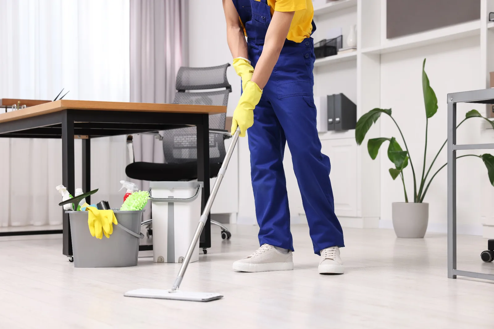 A cleaner mops a bright office floor